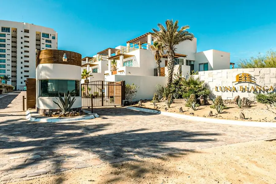 Entrance to the Luna Blanca condominium, with its sign and palm trees, in Playa Encanto, Puerto Peñasco
