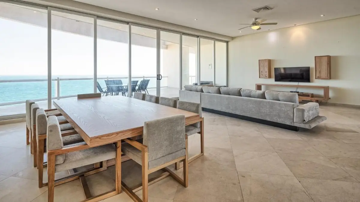 Penthouse living and dining area by the picture windows facing the ocean